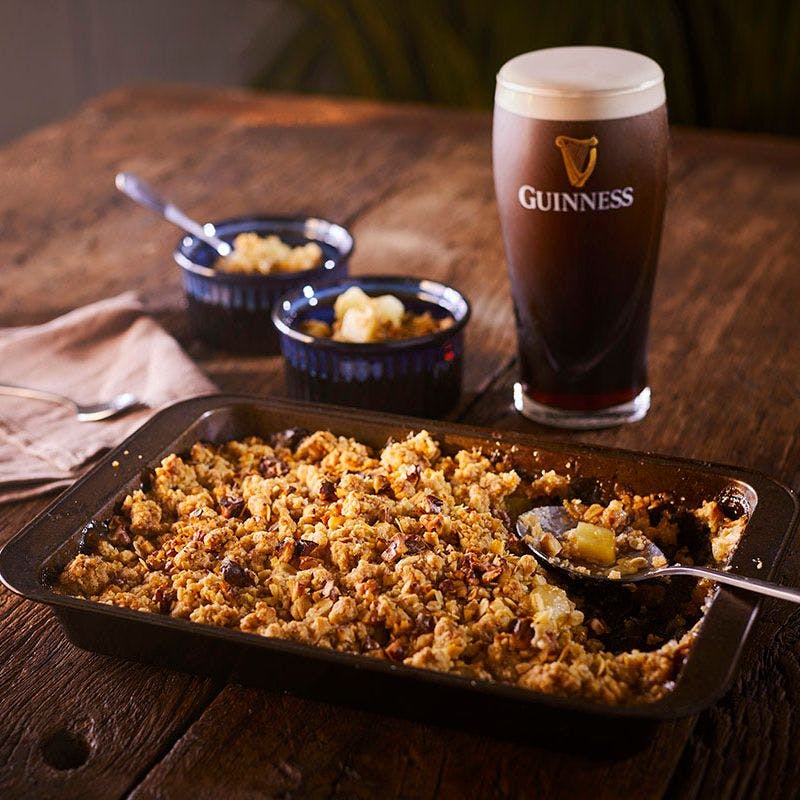 apple crumble in a baking dish with a pint of Guinness