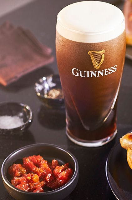 hot dog with relish and onions and a pint of Guinness