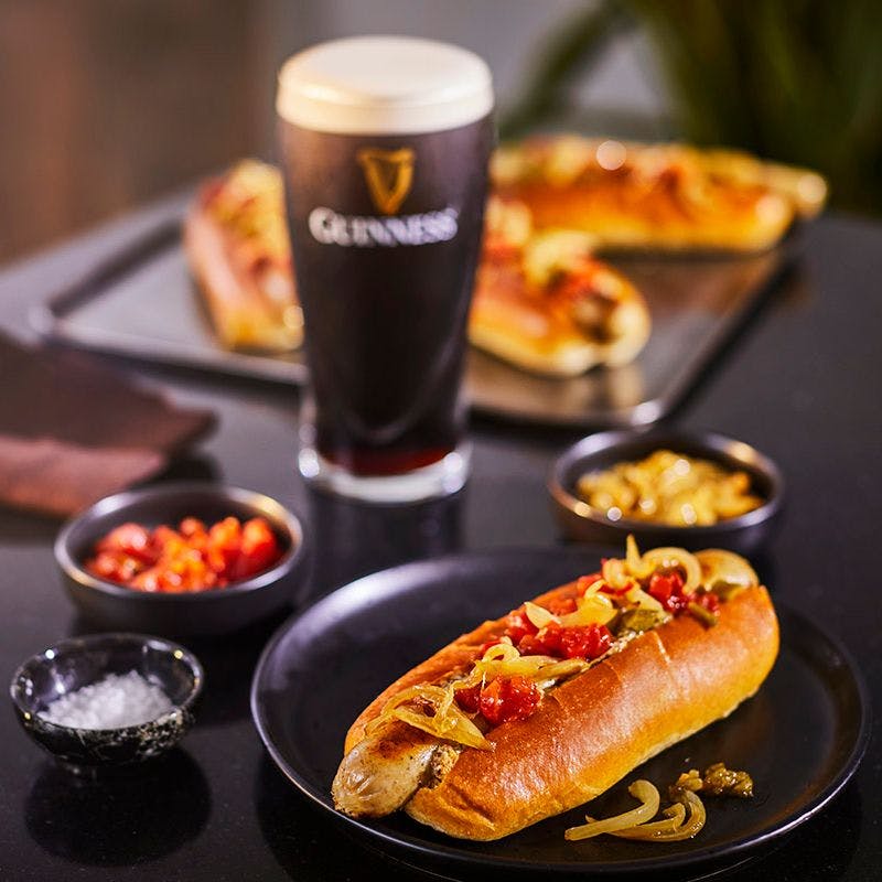 hot dog with relish and onions and a pint of Guinness