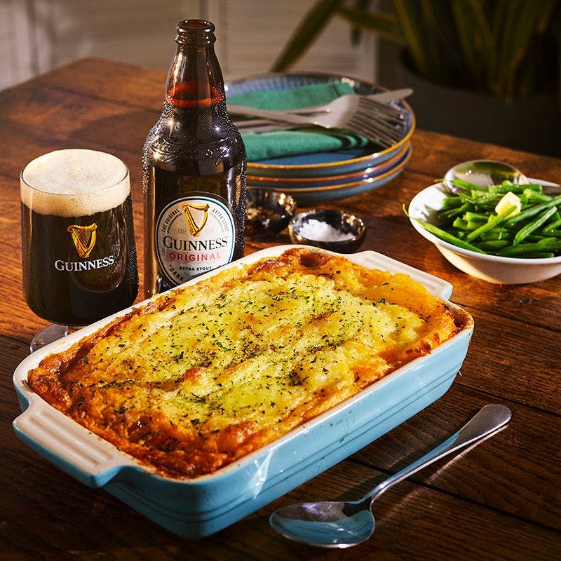 Bottle of Guinness with Shepards pie and green beans