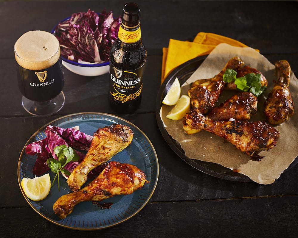 Bottle of Guinness Foreign extra with chicken drumsticks