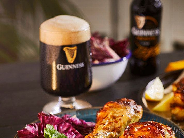 Bottle of Guinness Foreign extra with chicken drumsticks