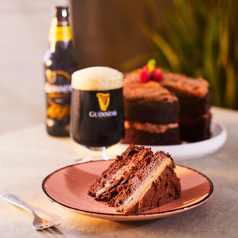 Bottle of Guinness served with a slice of chocolate cake