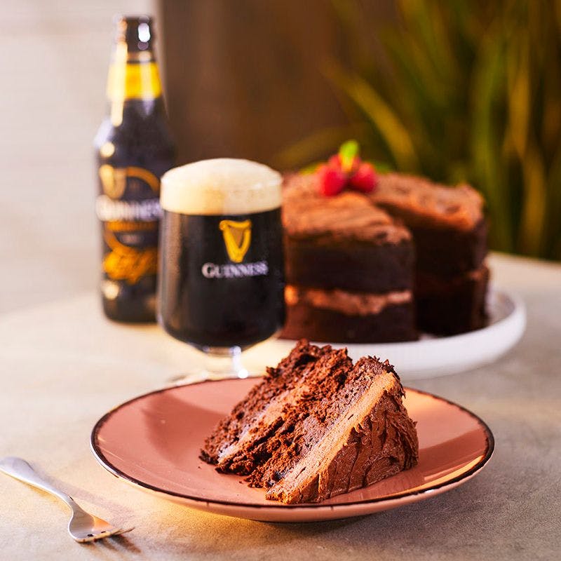 Bottle of Guinness served with a slice of chocolate cake