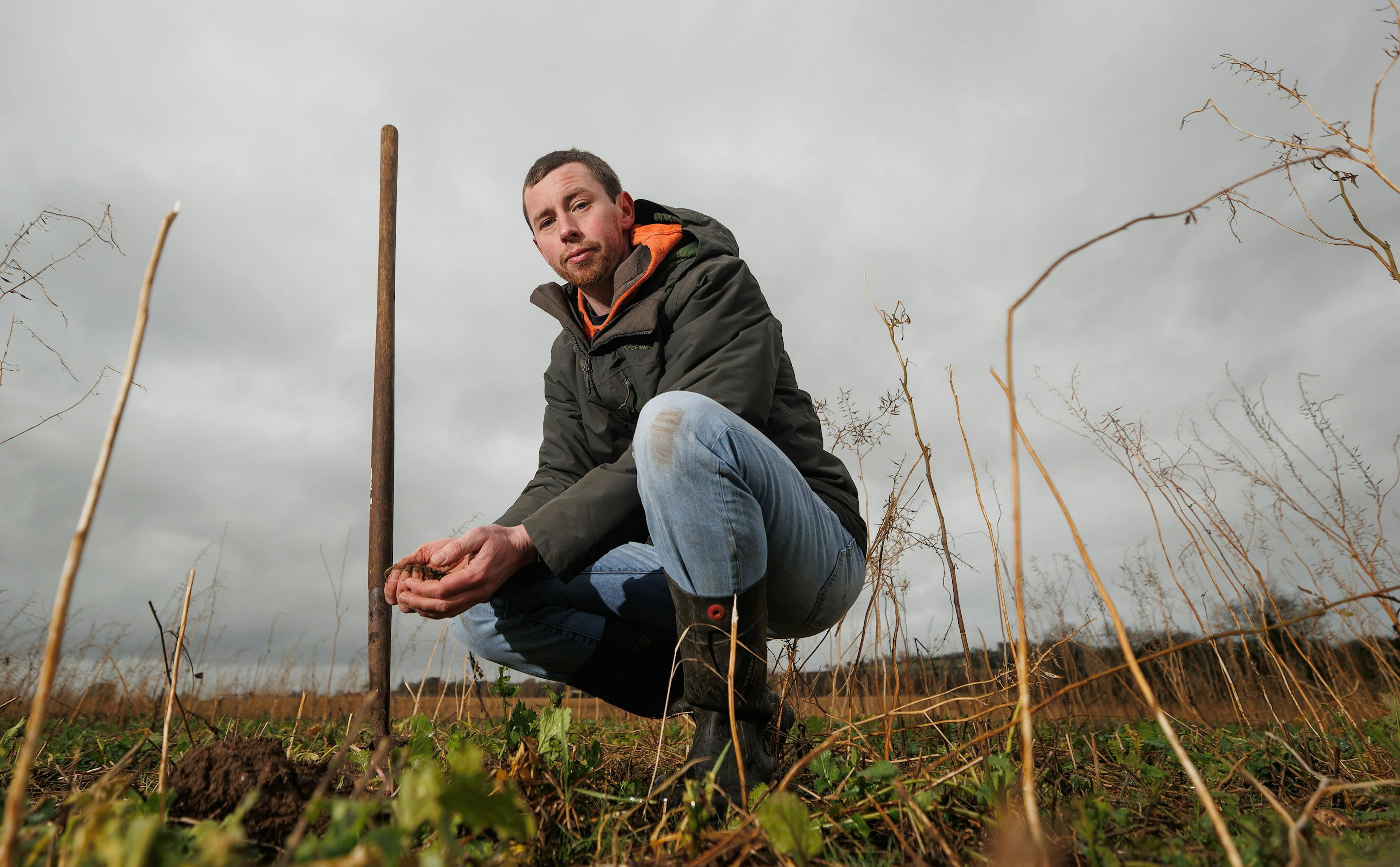 Image of a farmer crouching in the field