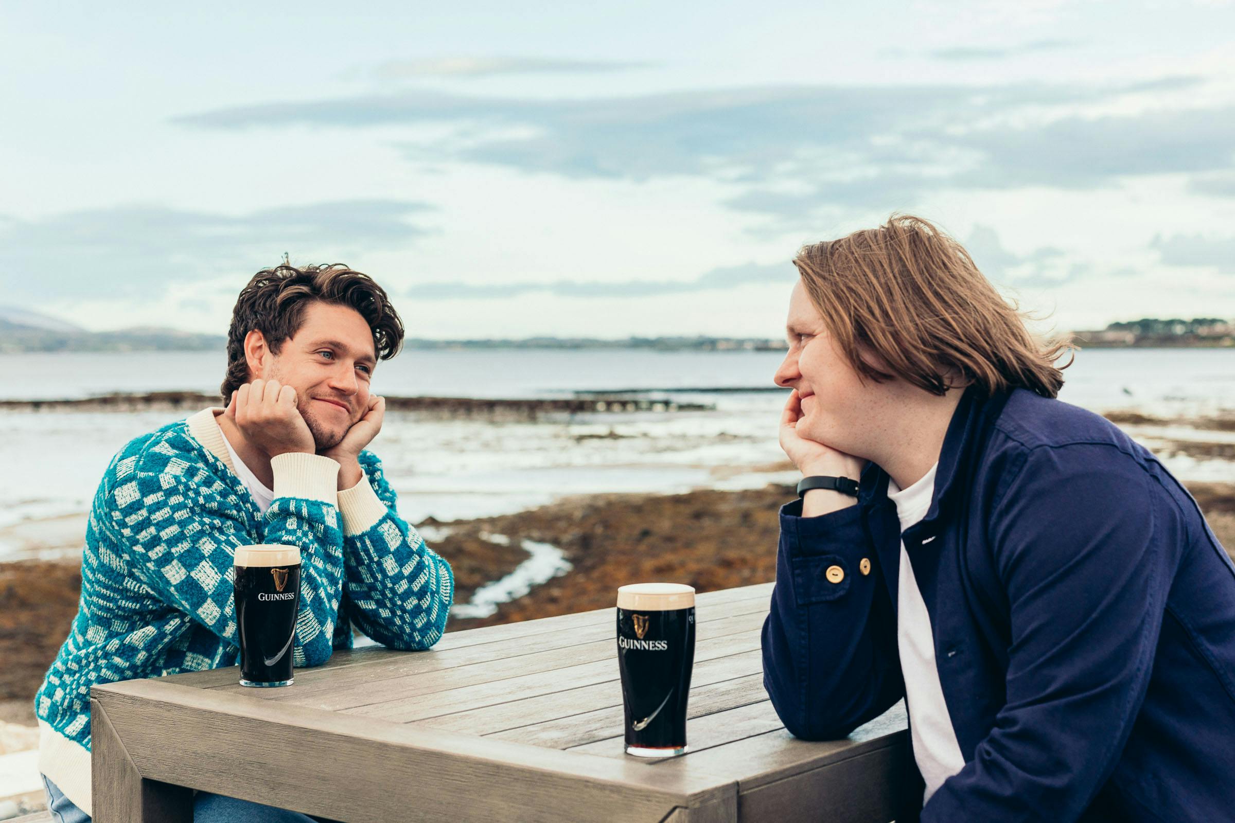 chatting at the beach with two glasses of guinness